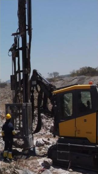 Tulela operator beside a surface drill rig