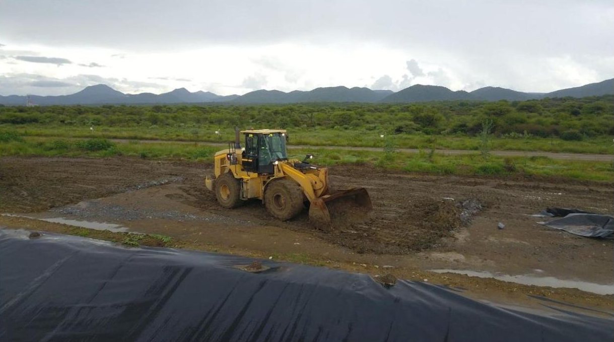 Wheel loader working beside a lined tailings facility